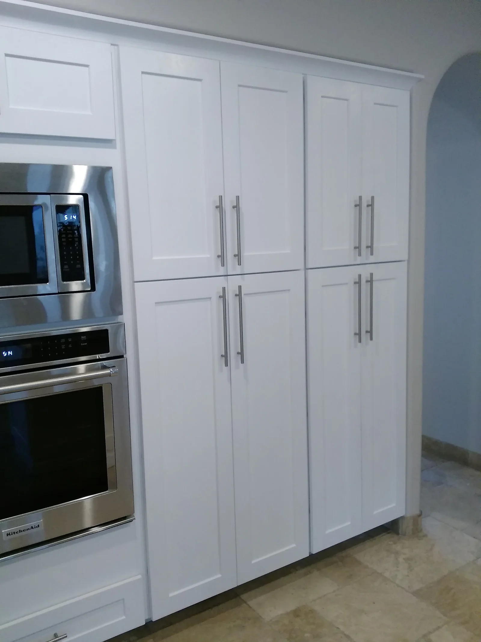 White shaker cabinets with stainless steel handles and KitchenAid appliances in modern kitchen