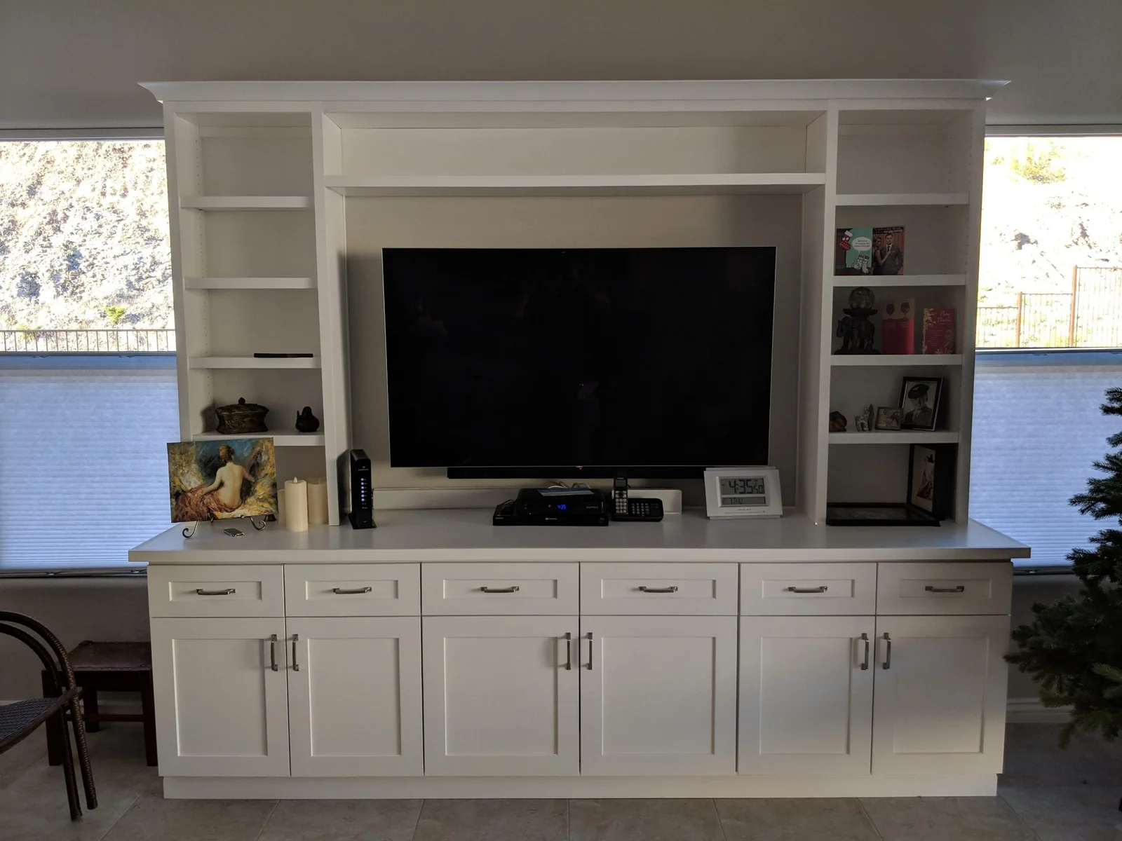 White painted cabinetry entertainment center with shaker doors, open shelving, and integrated TV wall