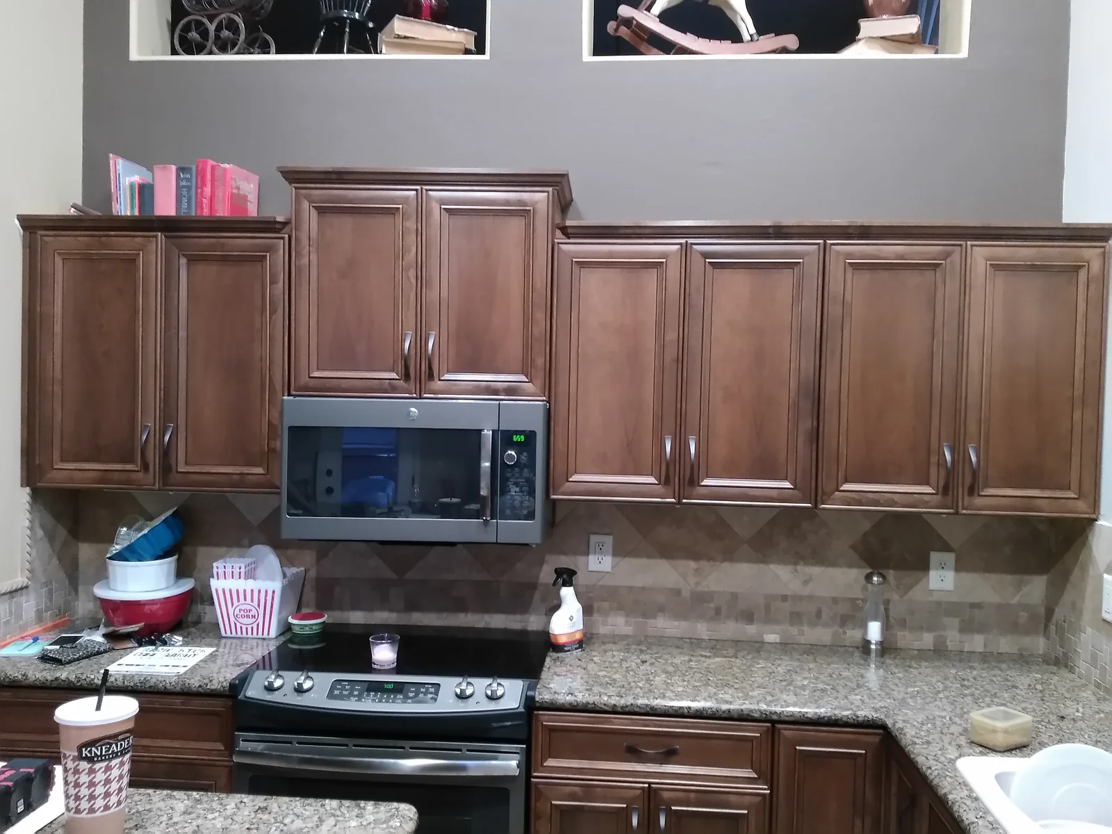 Brown raised-panel kitchen cabinets with granite countertops and stainless steel appliances