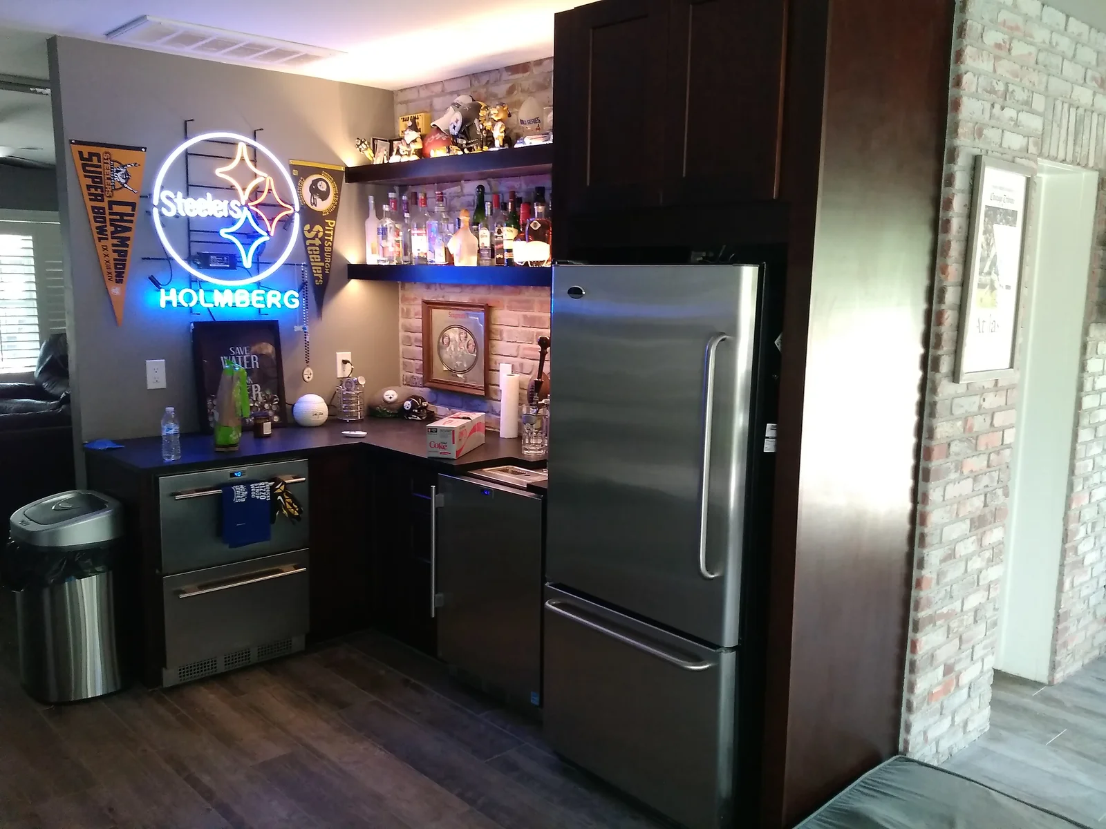 Dark cabinetry kitchen with stainless steel appliances, floating shelves, and neon accent lighting