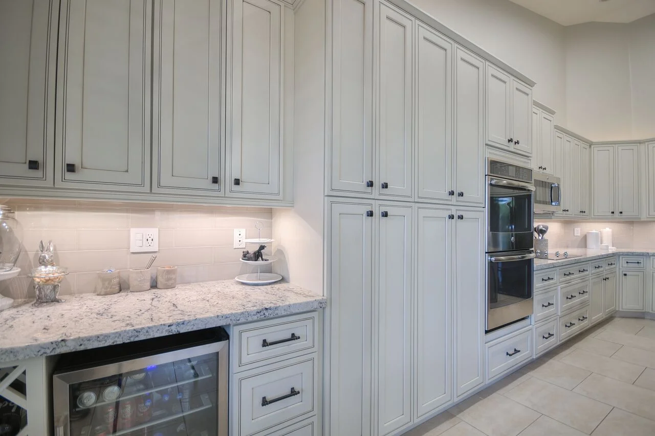 Light gray shaker cabinets, granite countertops, subway tile backsplash, stainless steel appliances