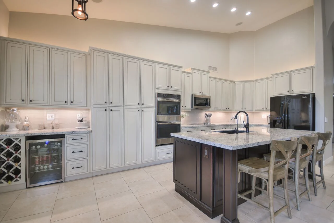 White inset cabinetry kitchen with dark wood island, granite counters, and stainless steel appliances