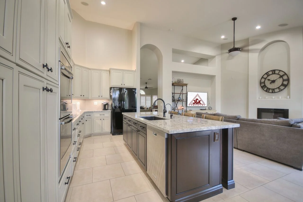 White cabinetry kitchen with dark wood island, granite countertops, and stainless steel appliances